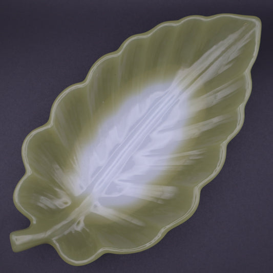 Green leaf-shaped dish on a dark background