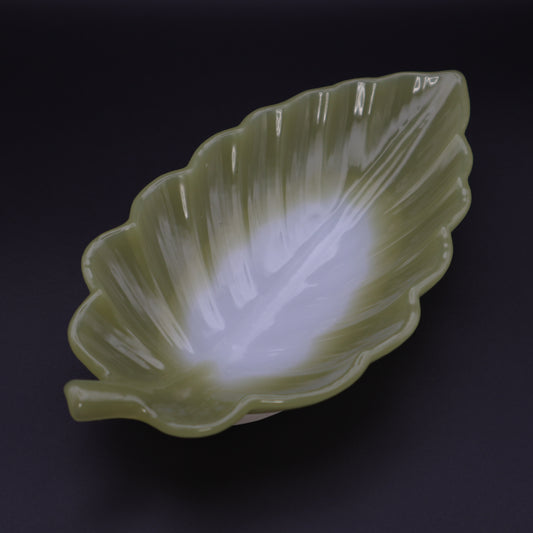 Green leaf-shaped resin dish on a black background